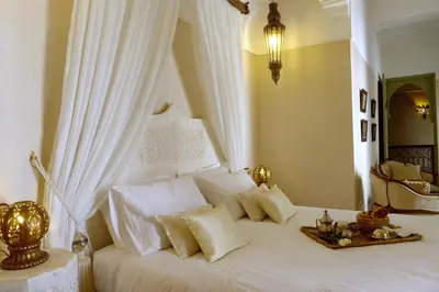 a bedroom with a white bed with white pillows at Riad Palacio De Las Especias in Marrakech