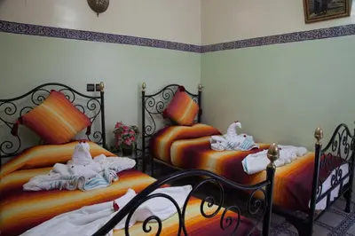 a bedroom with two beds with towels on them at Riad Saad in Marrakech