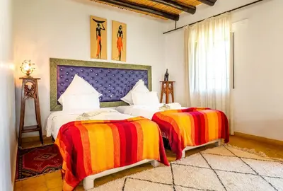 a bedroom with two beds with colorful blankets at Kasbah Alili in Marrakech