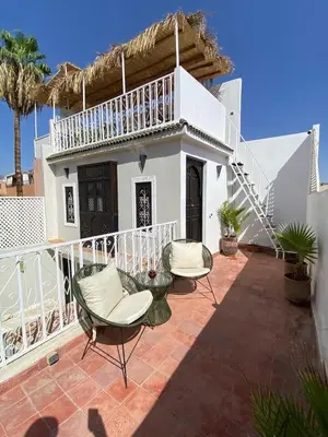 a patio with two chairs and a balcony at Riad Casa Sophia in Marrakech