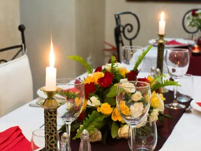 a table with glasses and a bouquet of flowers and candles at Riad Le Bel Oranger in Marrakech
