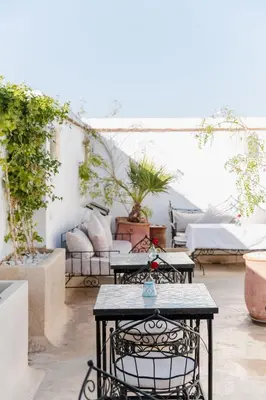 a patio with a table and chairs and plants at Riad Twilight in Marrakech