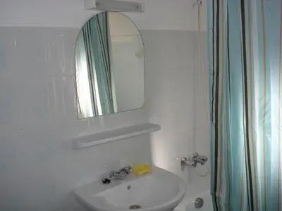 a white bathroom with a sink and a mirror at Riad Hicham in Marrakech in Marrakech