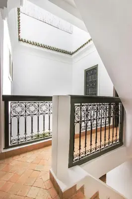 a staircase in a house with a wrought iron railing at Riad Myla - 2mn de Jemaa El Fna in Marrakech