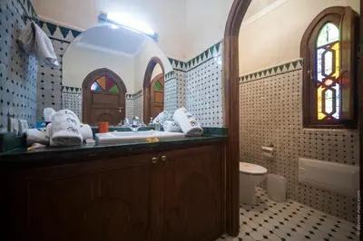 a bathroom with a sink and a toilet and a window at Riad Bab Tilila in Marrakech