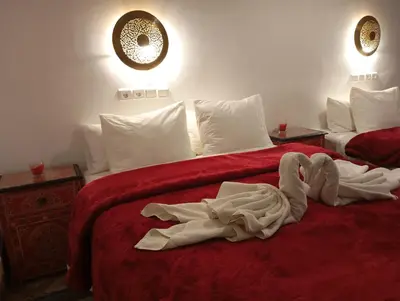 a hotel room with two beds with towels on them at Riad Papadou in Marrakech