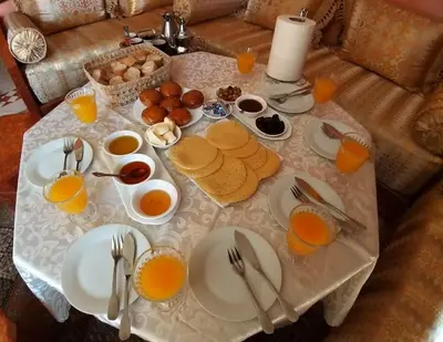 a table with breakfast foods and orange juice on it at Marrakech Family appartements in Marrakech