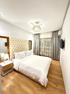 a bedroom with a large white bed and a window at Appartement haut standing in Marrakech