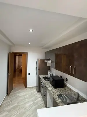 a kitchen with a counter top and a refrigerator at Appartement haut standing in Marrakech