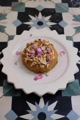 a donut on a white plate on a table at Riad L'Atelier in Marrakech