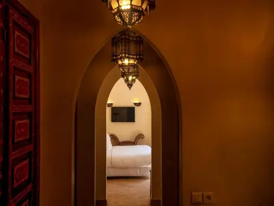 an arched hallway with a bed and a chandelier at Riad Il Parco dei Principi in Marrakech