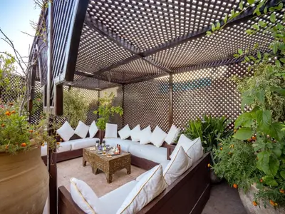 an outdoor patio with white couches and a table at Riad Il Parco dei Principi in Marrakech