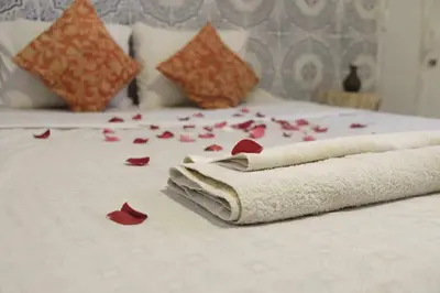 a bed with red rose petals on it at Hannah House Marrakech in Marrakech