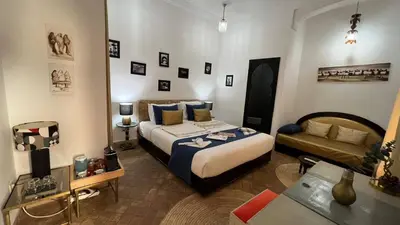 a hotel room with a bed and a couch at RIAD PÉNÉLOPE Marrakech in Marrakech