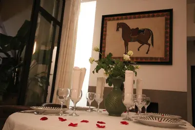a table with a vase with a horse picture on the wall at RIAD PÉNÉLOPE Marrakech in Marrakech