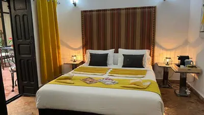 a bedroom with a large bed with a yellow blanket at RIAD PÉNÉLOPE Marrakech in Marrakech
