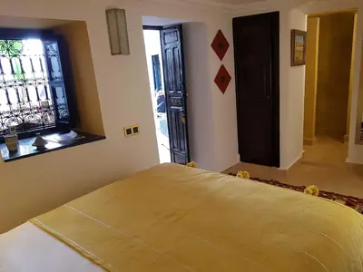 a room with a bed and a window and a door at Riad Bilkis Votre Maison Marrakech in Marrakech