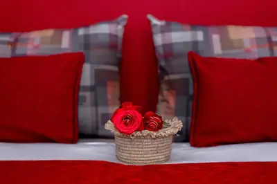 a red rose in a basket on a bed with pillows at Riad Bilkis Votre Maison Marrakech in Marrakech