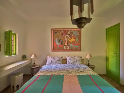 a bedroom with a bed and a painting on the wall at Riad Volubilis in Marrakech