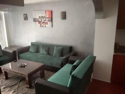 a living room with a green couch and a table at appartment achwaq in Marrakech