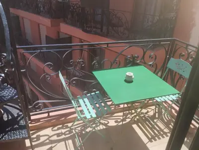 a green table and chairs on a balcony at appartment achwaq in Marrakech