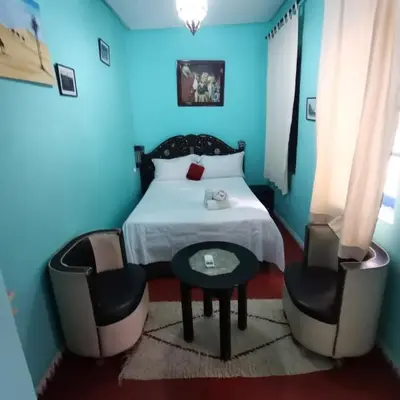 a blue bedroom with a bed and two chairs at RIAD DAR LFONOUN in Marrakech