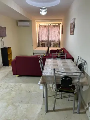 a living room with a table and a red couch at Appartement 33 in Marrakech