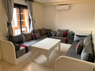 a living room with a couch and a table at Victor hugo Appartement in Marrakech
