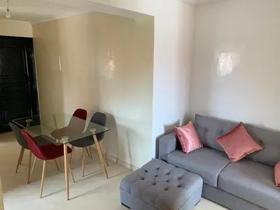 a living room with a couch and a glass table at Victor hugo Appartement in Marrakech