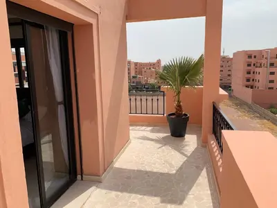a balcony with a potted plant on a building at Victor hugo Appartement in Marrakech