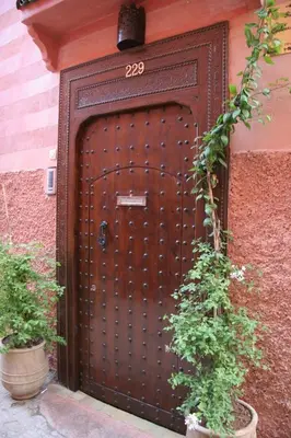a large wooden door with the number on it at Riad Couleurs du Sud in Marrakech