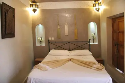 a bedroom with a white bed with a head board at Riad Couleurs du Sud in Marrakech