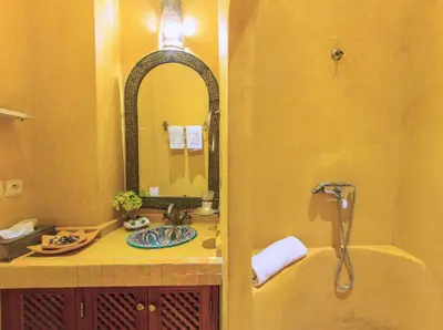 a bathroom with a tub and a sink and a mirror at Riad Couleurs du Sud in Marrakech