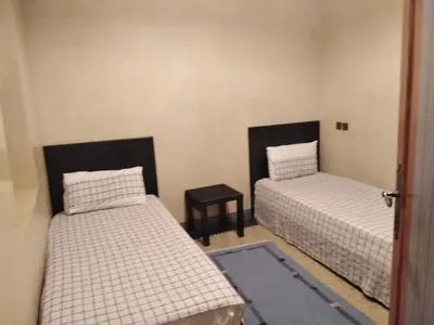 a room with two beds and a table in it at Dar Rmila 4 in Marrakech