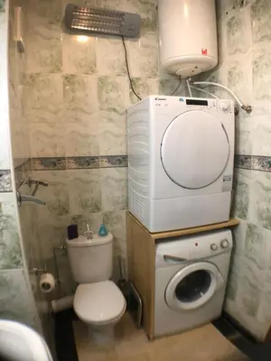 a bathroom with a toilet and a washing machine at Annakil Appart in Marrakech