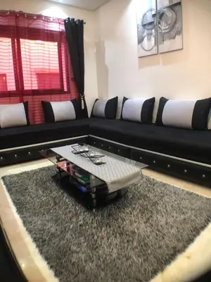 a living room with a black couch and a coffee table at Annakil Appart in Marrakech