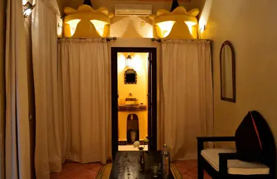 a room with curtains and a mirror and a chair at Riad Charik in Marrakech