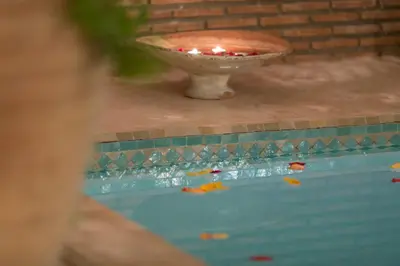 a bowl with a candle in the middle of a pool at Riad El Maktoub in Marrakech