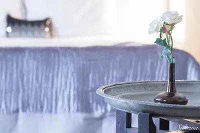a vase with a flower in it on a table at Riad El Maktoub in Marrakech