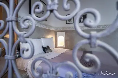 a bedroom with a bed with white sheets and a pillow at Riad El Maktoub in Marrakech