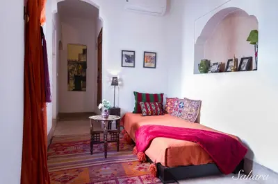 a bedroom with a bed and a table at Riad El Maktoub in Marrakech