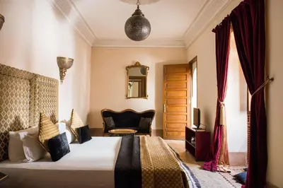 a bedroom with a bed and a chair and a mirror at Riad Zamzam & Spa in Marrakech