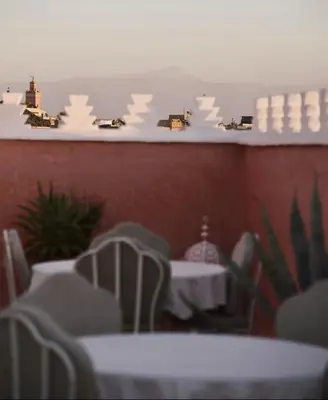 a restaurant with white tables and white chairs at Riad Zamzam & Spa in Marrakech