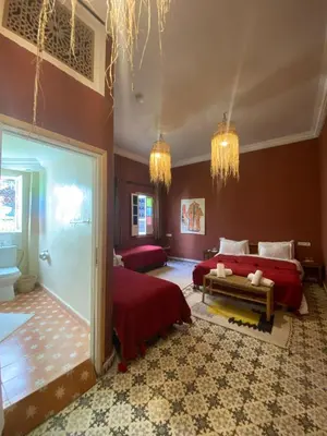 a large bedroom with two beds and a room with at Riad Milouda in Marrakech