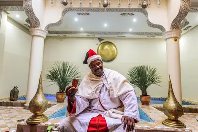 a man in a santa hat sitting in a room at Riad Milouda in Marrakech