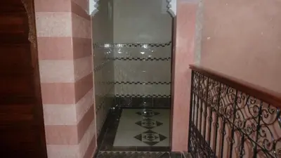 a hallway with a staircase with a tile floor and a shower at Hotel Aday in Marrakech