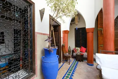 a room with a gate and a blue vase with a plant in it at Riad Basma Marrakech in Marrakech