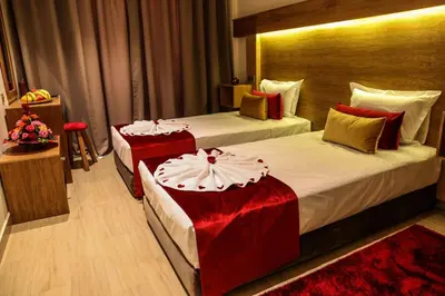 a hotel room with two beds with red pillows at LE VOYAGEUR MARRAKECH in Marrakech