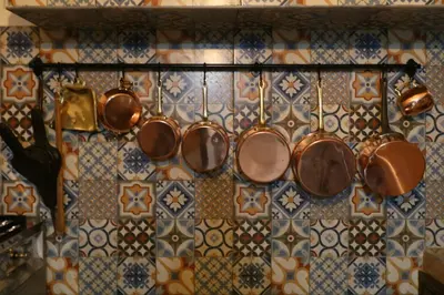 a bunch of copper pots and pans hanging on a wall at Riad Dada Mouss & Suites in Marrakech