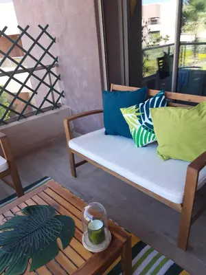 a porch with a bench and a coffee table at Jade Golf City in Marrakech